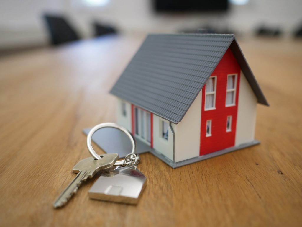 toy house on table with keys as a symbol of renewing mortgage.