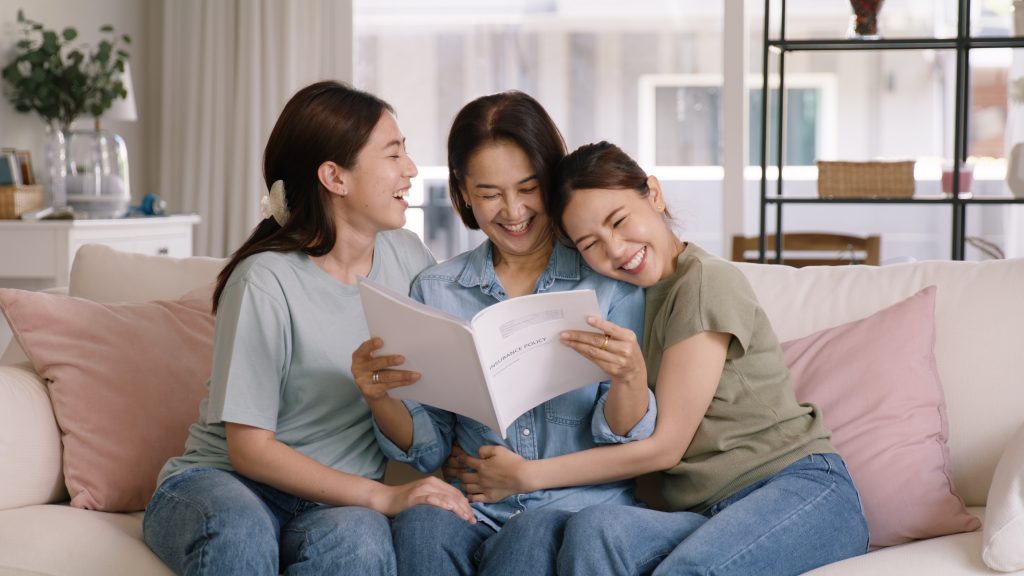 Smiling family in their new home, holding mortgage life insurance documents